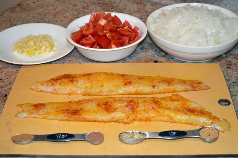 View of ingredients - cod fillets, tomatoes, onions, spices