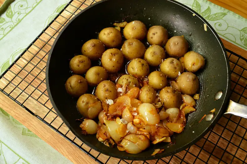 Adding potatoes to the onions mixture for the dish