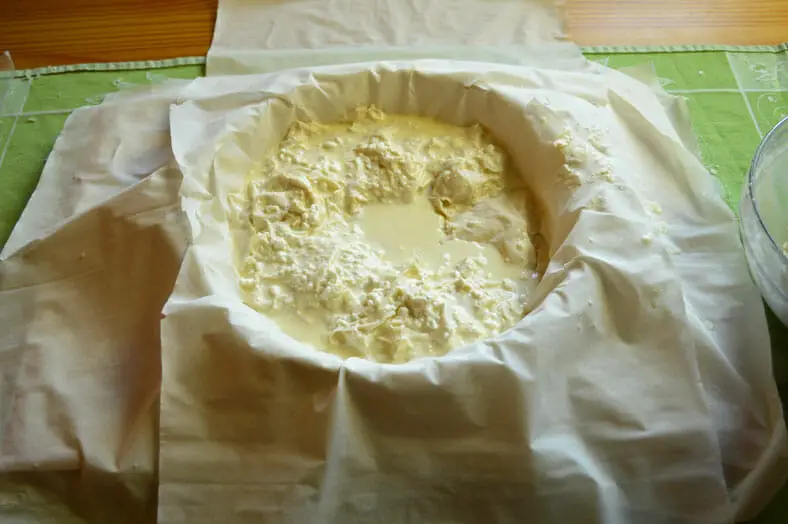 The beginnings of your Gibanica (Serbian cheese pie) with the bottom layer of guzvar already spread out. Be careful not to let the phyllo dough dry out!