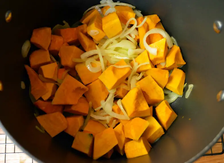 Cooking squash pieces with onion for soup