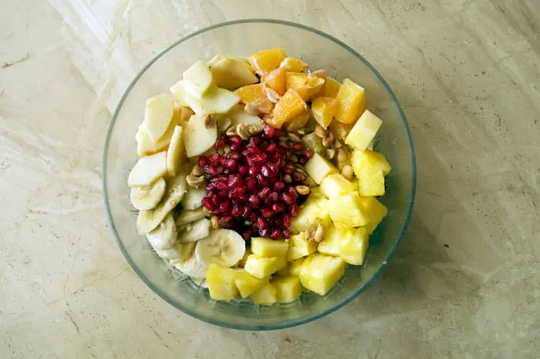 Mixing fruits and nuts that go into the salad