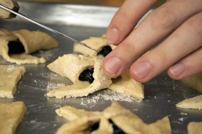 Folding cookies filled with jam and shaping them like pinwheel