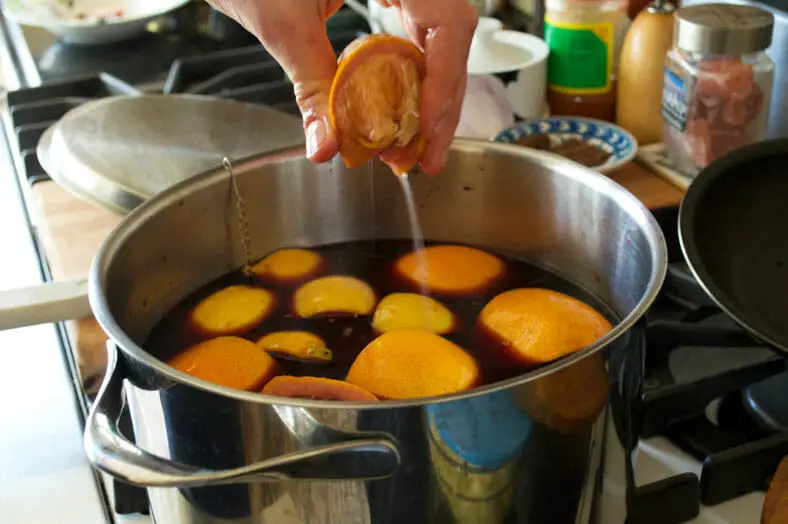 Squeezing oranges inside red wine
