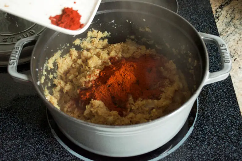 Adding paprika to the onion and spices mixture