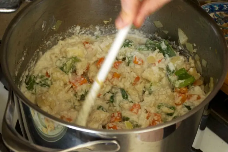 Adding coconut milk to the vegetables and cooking it till it thickens