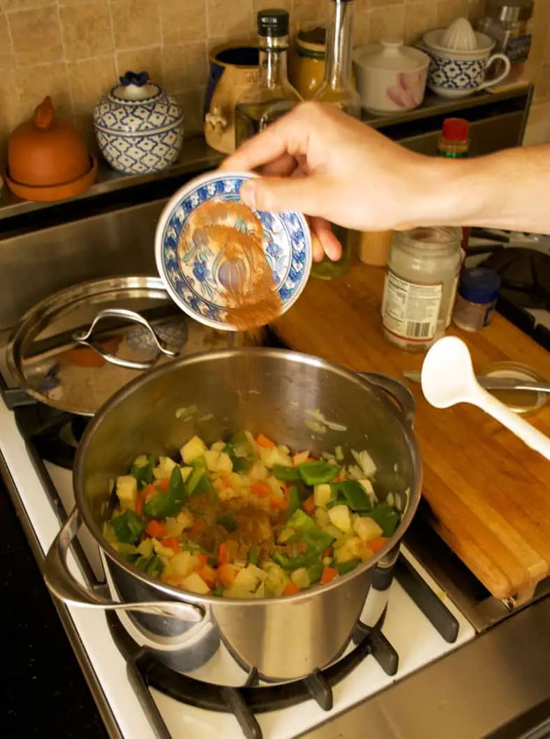 Adding cinnamon powder to the cooking vegetables