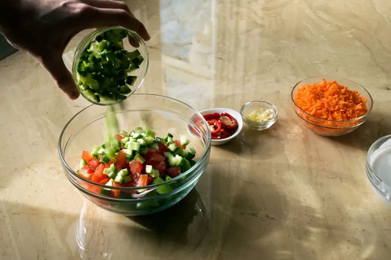 Mixing vegetables in a large clear bowl