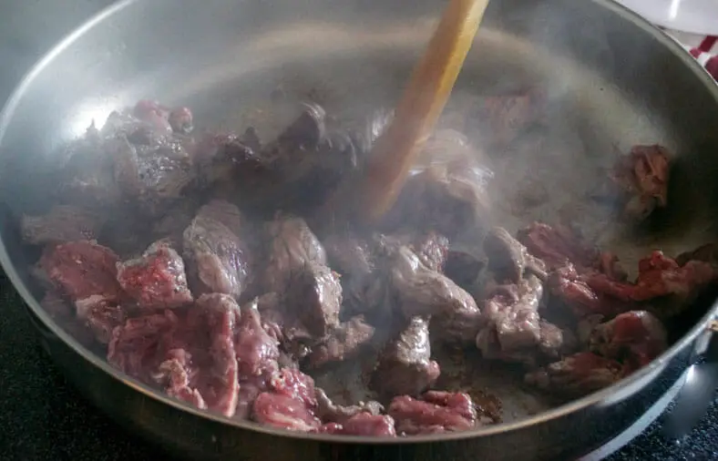 Cook and simmer the beef pieces till brown