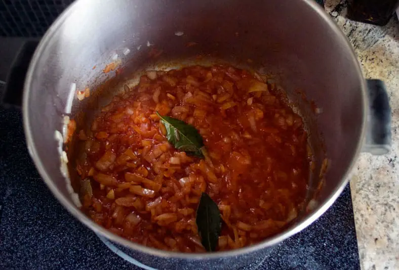 Cooking tomatoes and onion in a pan for rice