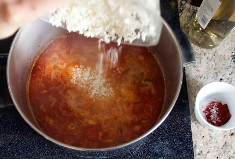 Adding rice to the tomato and onion mixture