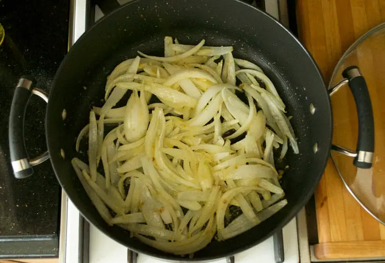 Cooking onions in the pan for toppings