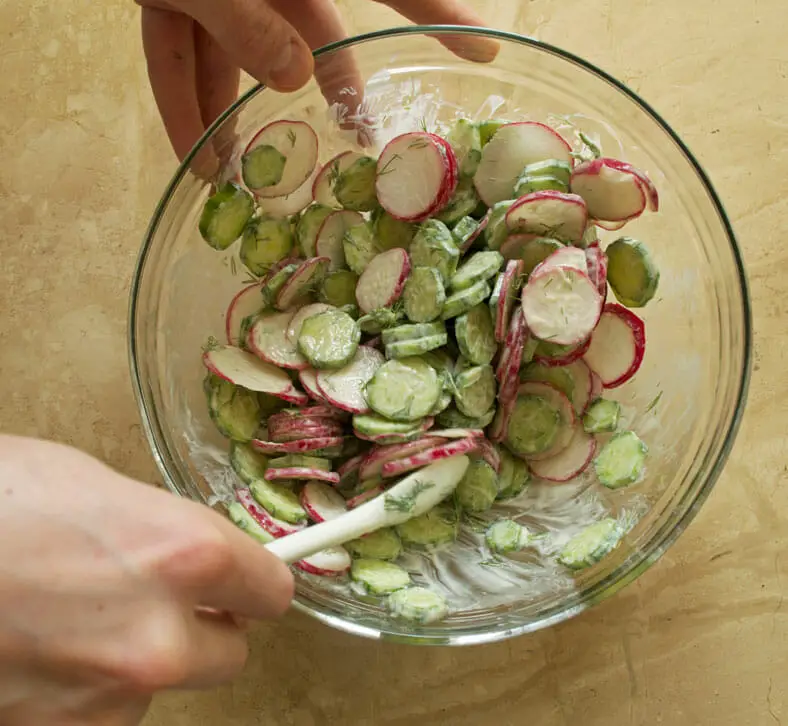Mixing cucumber and radish with the dressing properly