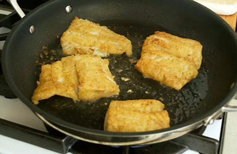 Frying of fish fillets in oil for the dish