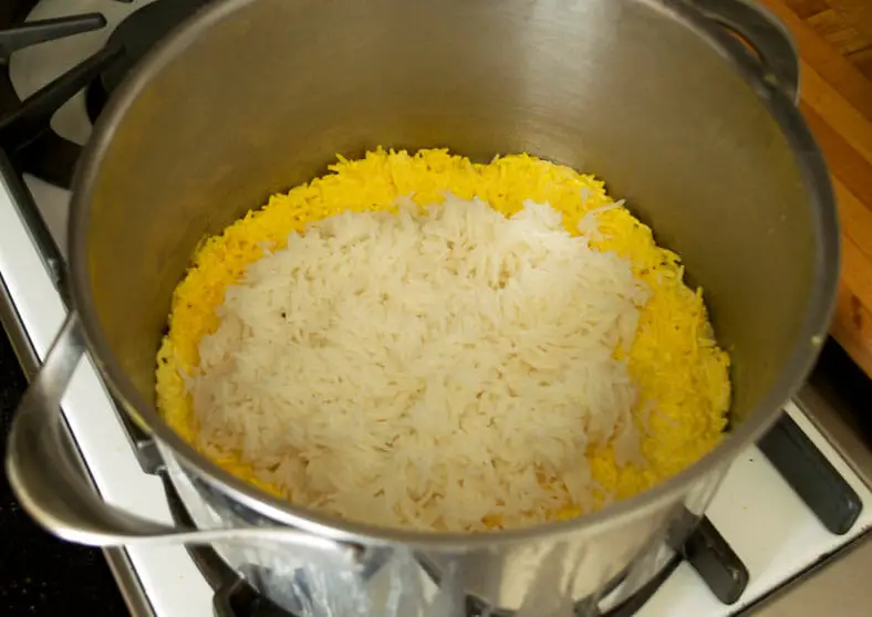 Saffron infused rice in bottom with yogurt mixed basmati rice on top