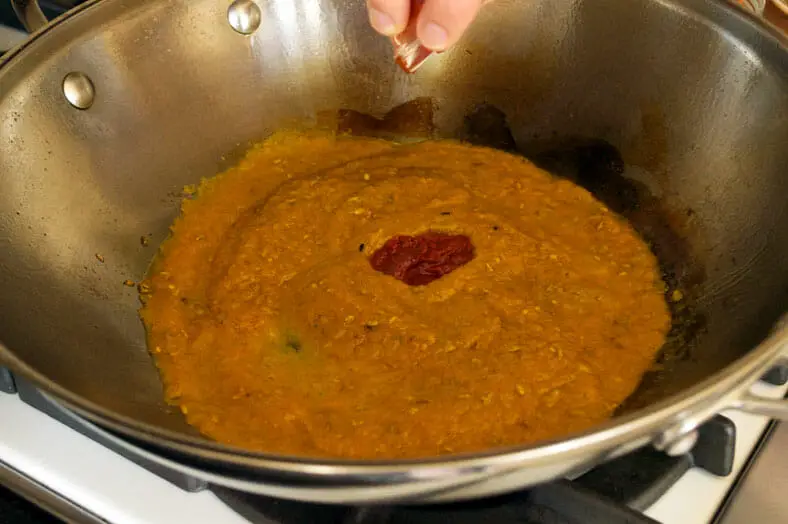 Adding tomato sauce to the paste