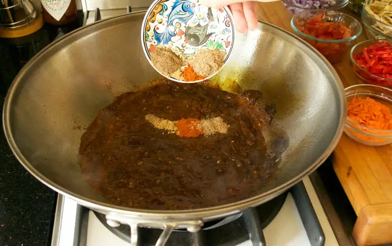 Adding dry spices to the cooking paste