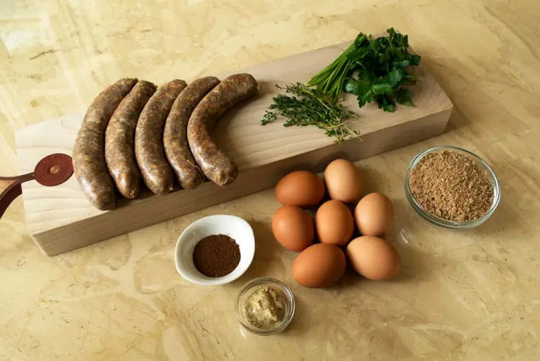View of ingredients - eggs, sausage meat, chives, parsley, breadcrumbs, thyme