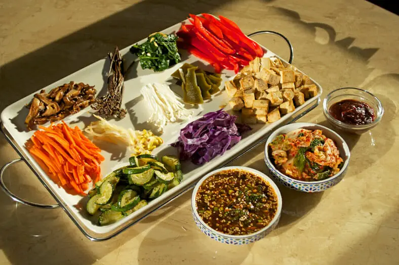 Prepared dish with variety of toppings to select - tofu, carrots, dashima, bell peppers, red cabbage and more