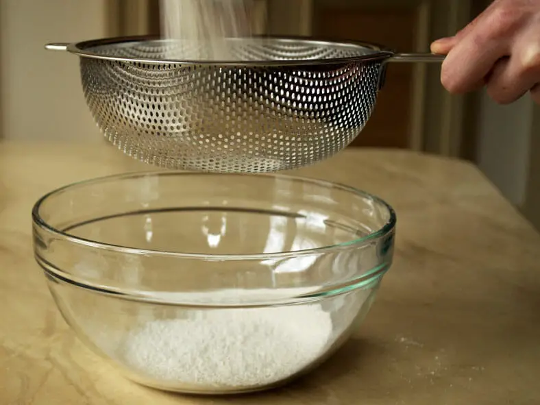 Sieving of flour into bowl