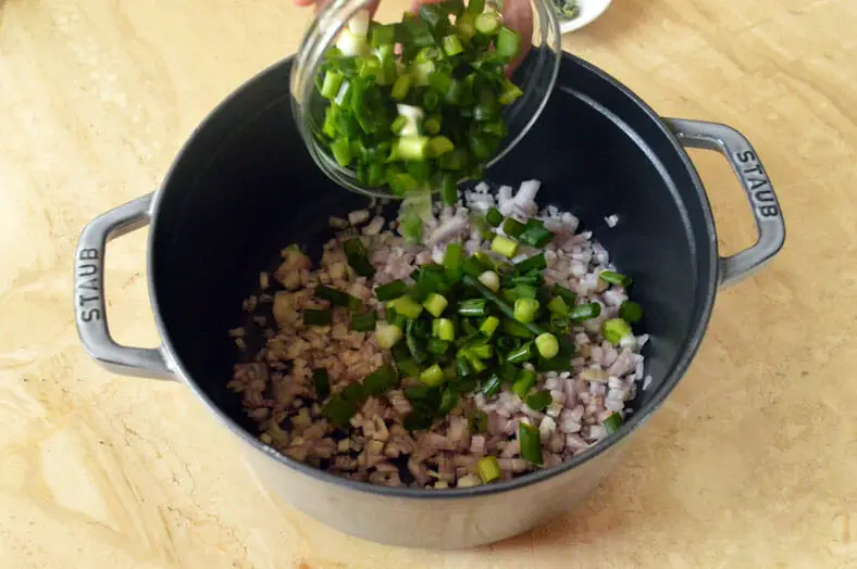 Adding shallots and scallions in a pan