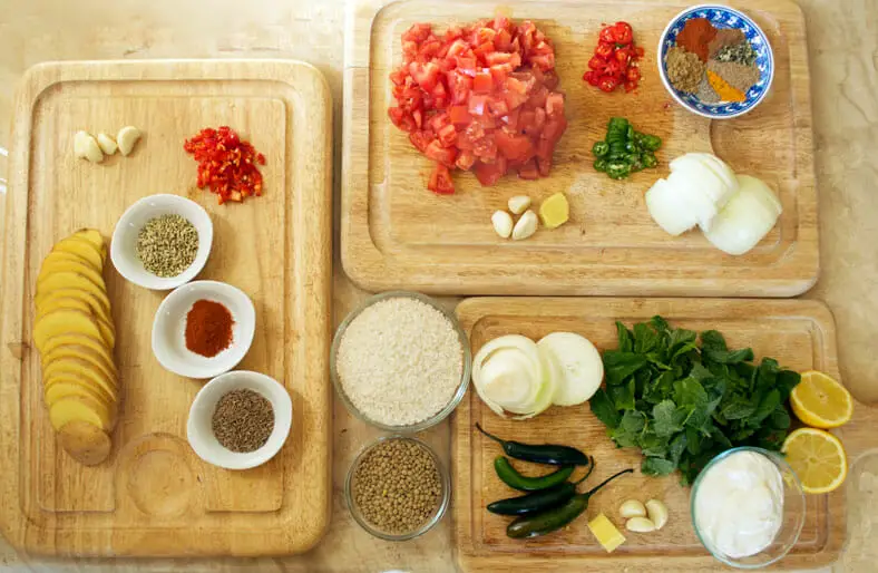 Ingredients - tomatoes, spices, potato slices, spices, chili pepper, lemon, onions, rice, lentils