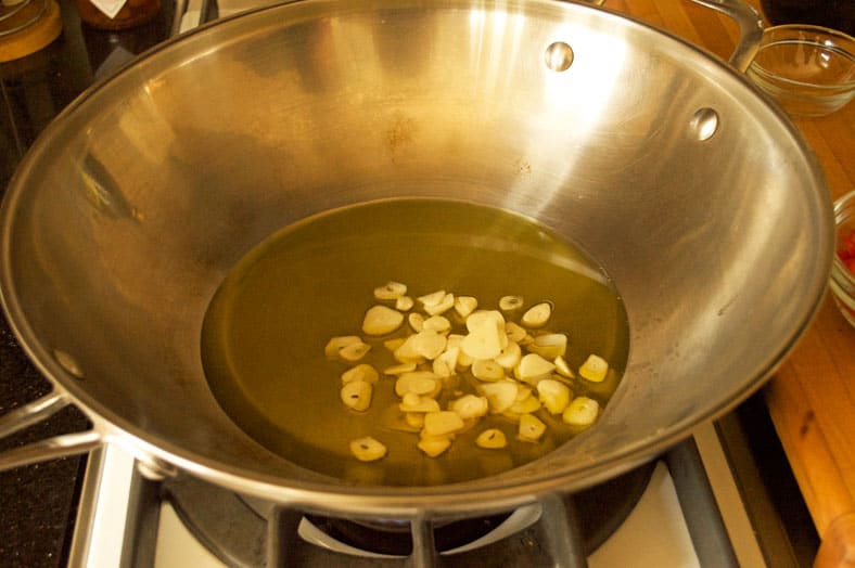 Adding garlic to the oil in wok