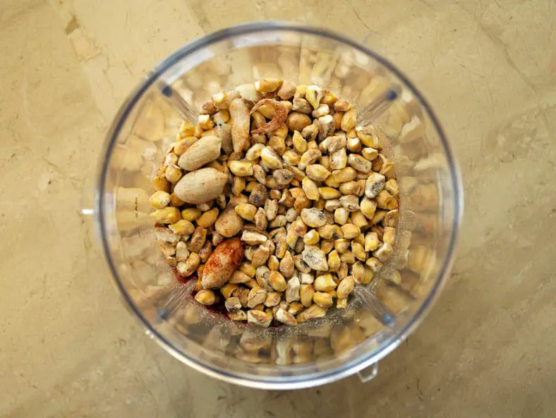 Roasted groundnuts and dried corn kernels in blender for powder