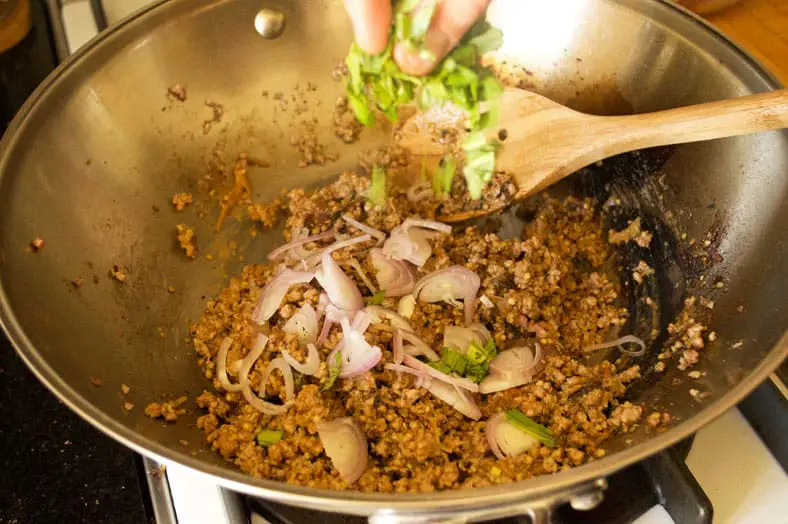 Adding shallots, cilantro, mint and other herbs to cooked pork