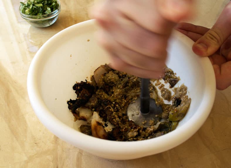 Making eggplant paste in mortar and pestle
