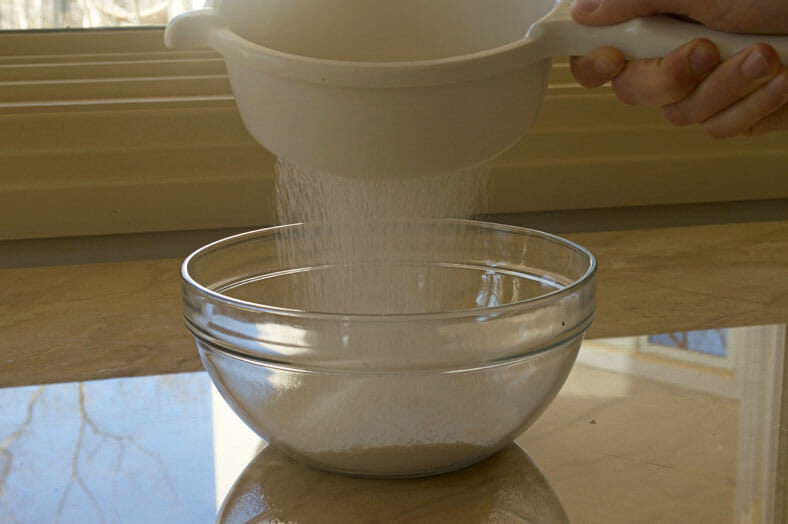 Sieving flour in bowl for batter
