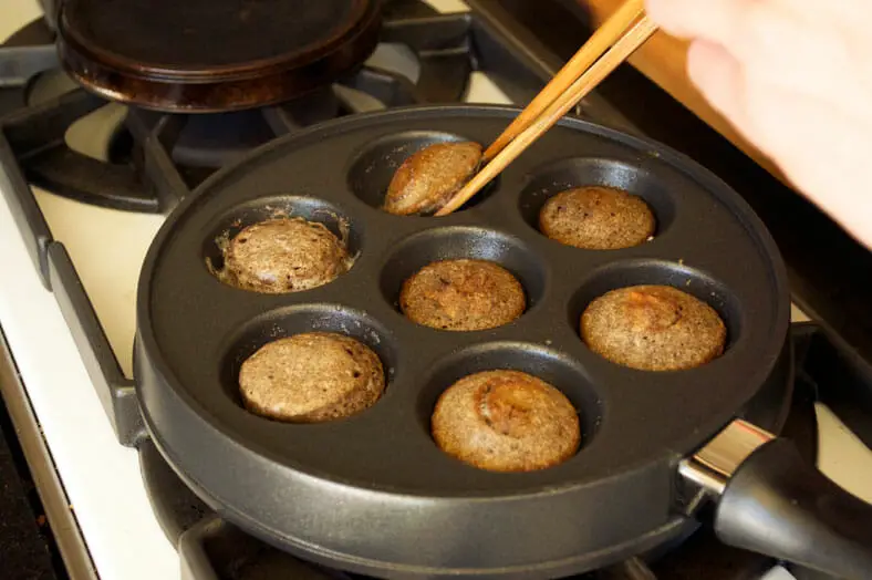Flipping pancake with chopsticks to cook on other side