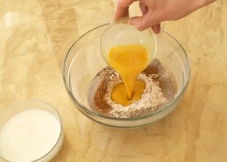 Adding beaten eggs to the flour