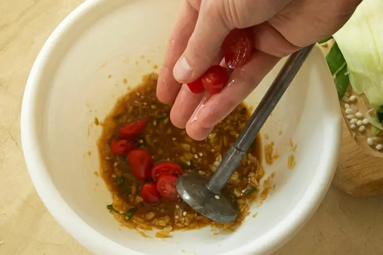 Adding cherry tomatoes to chili pepper and garlic mixture