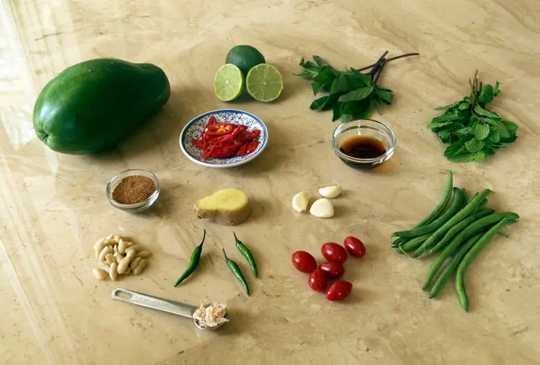 View of ingredients - papaya, lemon, chili pepper, garlic, ginger, mint, dried shrimps
