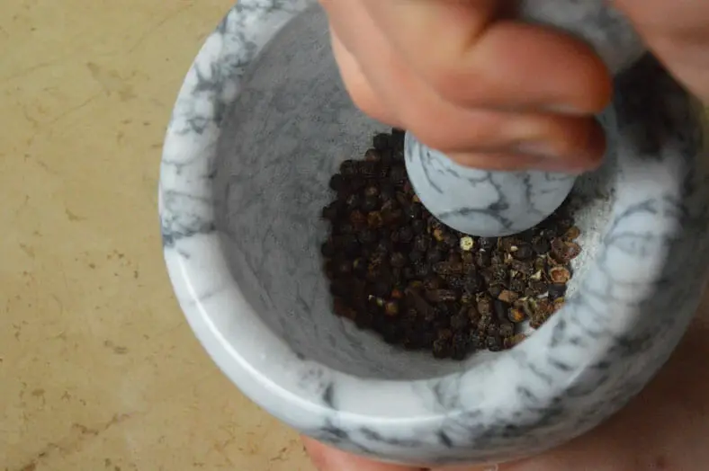 Grounding black pepper in mortar and pestle