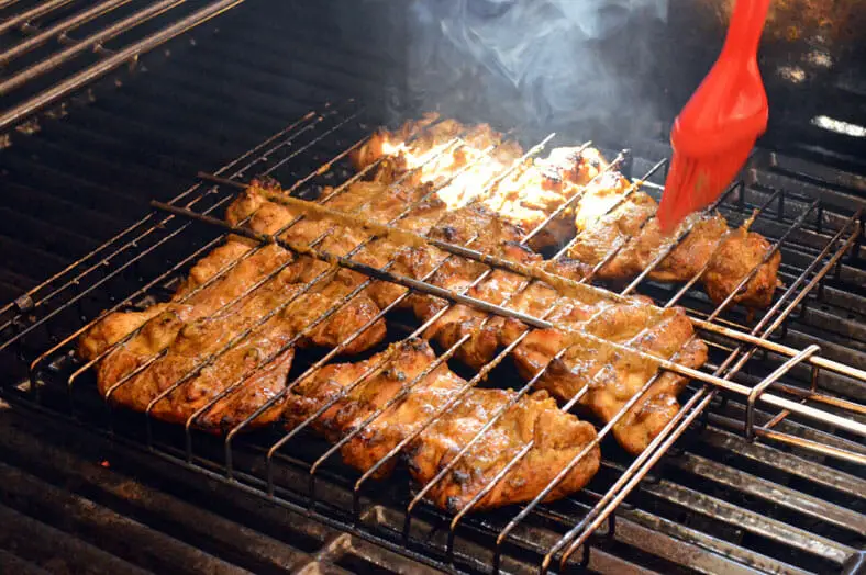 Brushing marinated grill chicken to avoid it being overcooked