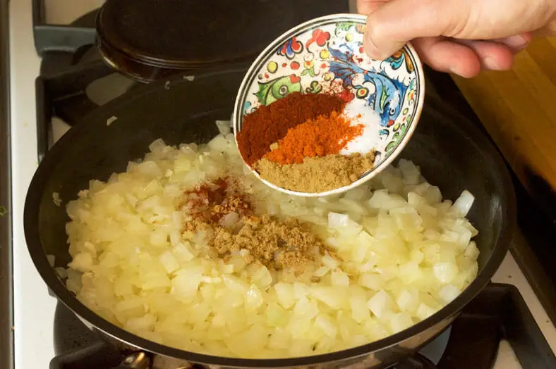 Spices being added to the vegetarian onion and mushroom filling