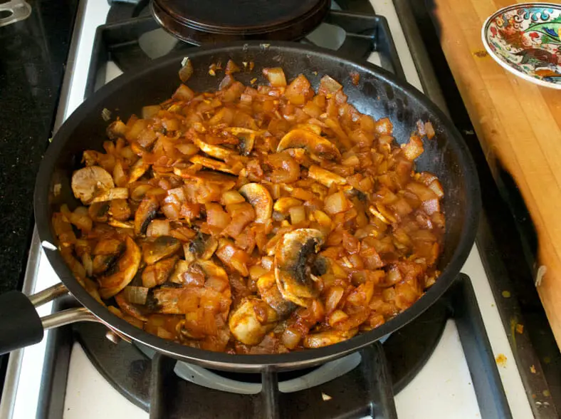 A spice-filled onion and mushroom vegetarian filling simmering before being compiled