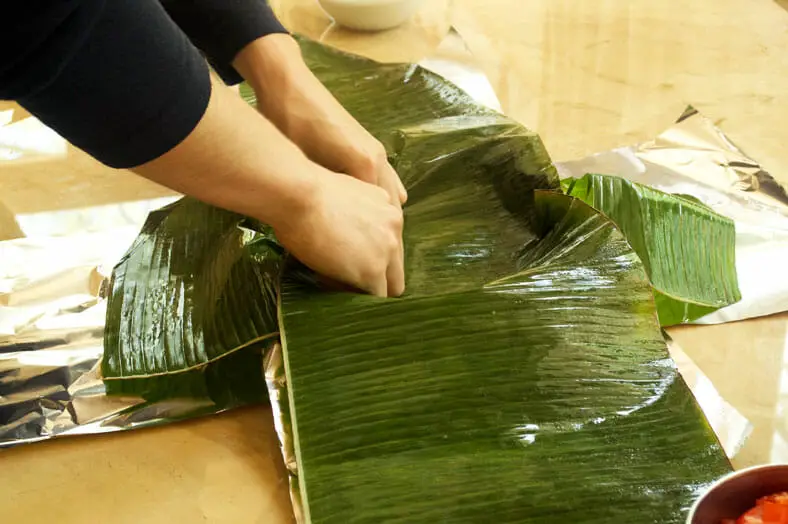 Lining a pan with a banana leaf for the New Caledonian (Kanak) dish Bougna