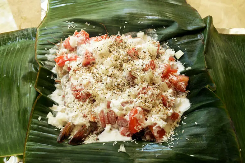 Banana leaf filled with yam onion prawns and tomato covered with coconut milk