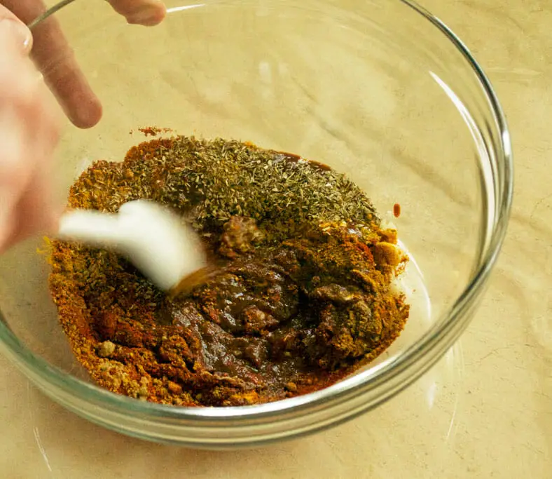 Mixing together the spices with the aji panca paste for Peruvian anticuchos