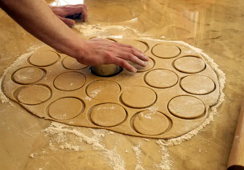 Cutting out circles of dough for Latvian piragi (bacon pie)