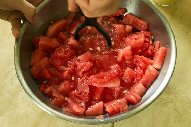 Smashing fresh watermelon for Tongan watermelon coconut drink