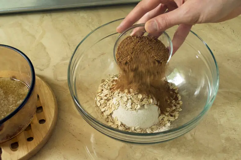 Adding sugar to flour and oats mixture