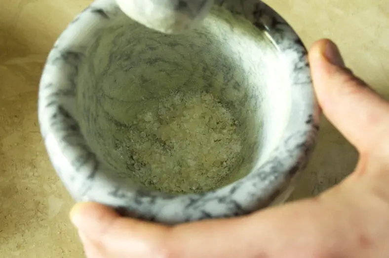 Grinding Mastic seeds in mortar and pestle for dough 