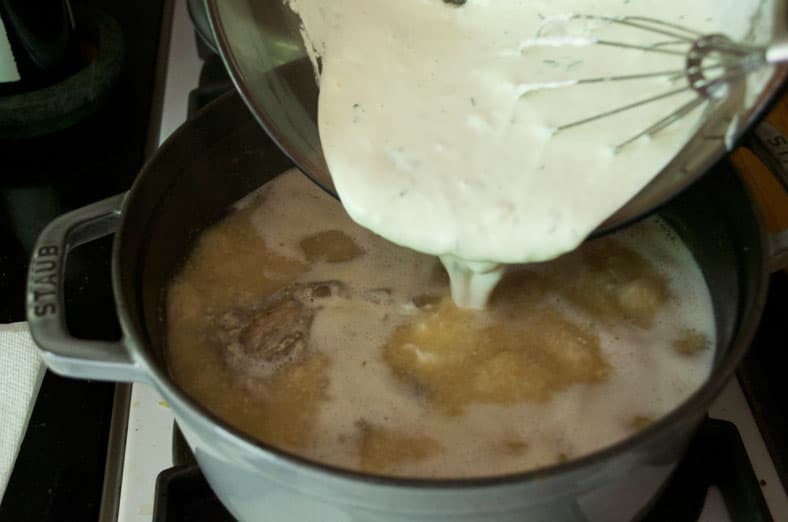 Adding a rich gravy sauce made of broth, yogurt and herbs for Jordanian Mansaf recipe. jameed is a yogurt