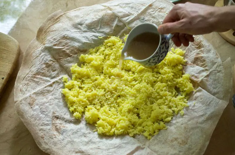 Pouring sauce over the cooked saffron rice