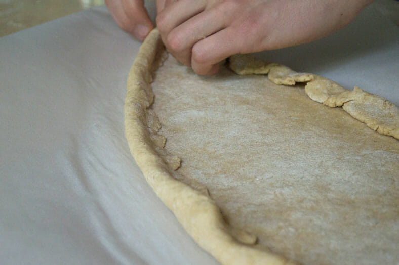 Shaping edges of dough into a boat shape 