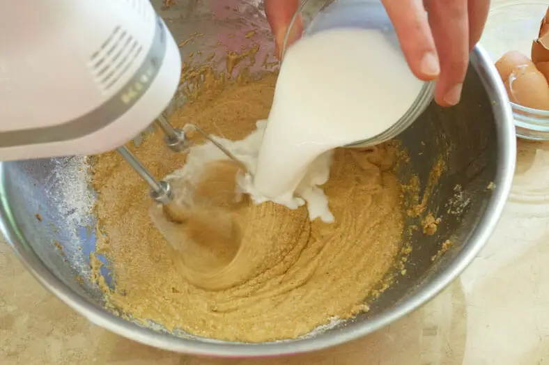 Adding milk to the mixture of cake