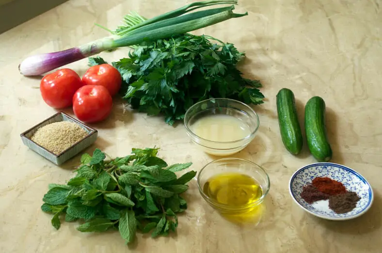 Ingredients - parsley, cucumber, bulgur, red onion, tomato salad with lemon juice and olive oil